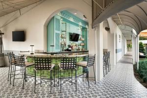 a patio with a bar with chairs and tables at Castle Hotel, Autograph Collection in Orlando