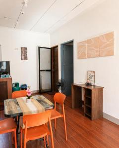 a dining room with a table and orange chairs at JRC Feel at Home in Puerto Princesa City