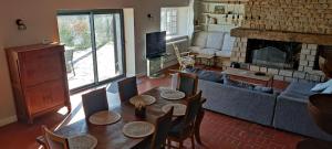 a living room with a couch and a table and a fireplace at Balcon des fées in Le Malzieu-Ville