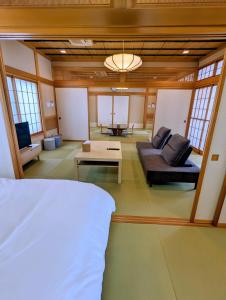 a bedroom with a bed and a living room at 和の貸切宿yanagiya in Daisen
