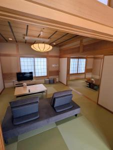 a large room with a table and two chairs at 和の貸切宿yanagiya in Daisen