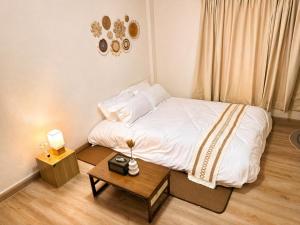 a small bedroom with a bed and a table at Nipat home petfriendly in Ban Khlong Prawet