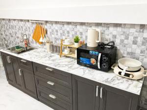 a kitchen with a counter top with a microwave at Nipat home petfriendly in Ban Khlong Prawet +9 photos