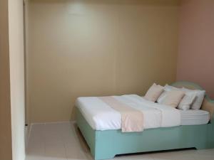 a bedroom with a blue bed with white sheets and pillows at Verde Royale Resort in Calasiao