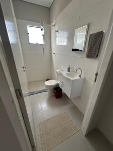 a white bathroom with a toilet and a sink at 05 Studios centro,proximo a rodoviaria-itapeva sp in Itapeva