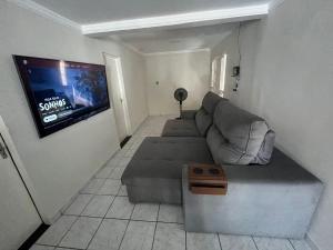 a living room with a couch and a flat screen tv at Casa ampla e confortável in Mossoró