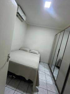 a small bedroom with a bed and a mirror at Casa ampla e confortável in Mossoró