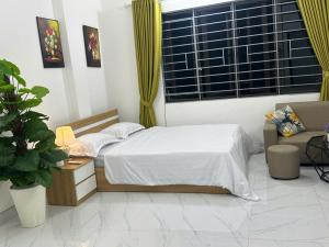 a bedroom with a bed and a couch and a window at Harmony Apartment in Hanoi