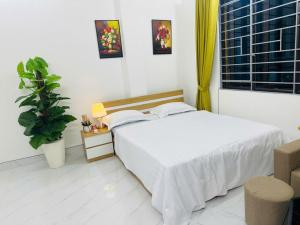 a bedroom with a bed and a potted plant at Harmony Apartment in Hanoi