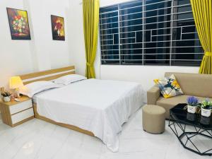 a bedroom with a bed and a couch and a window at Harmony Apartment in Hanoi