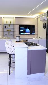 a kitchen with a stove and a tv on a wall at Bianca Villa in Al Rama