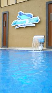 a water fountain in front of a building with a sign at Bianca Villa in Al Rama