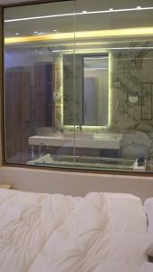 a bed in a room with a large window at Bianca Villa in Al Rama