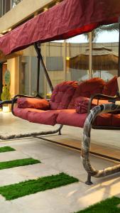 a group of red beds with grass on the floor at Bianca Villa in Al Rama