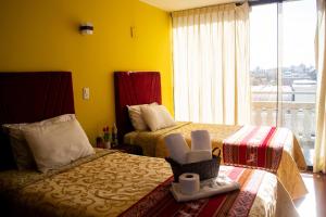 a hotel room with two beds and a window at Misti Hostel B&B in Arequipa