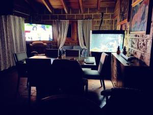 a dining room with a table and a television at Villa Rancho el piñón in Ezequiel Montes