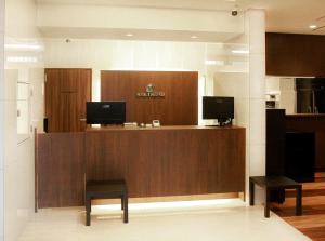 a lobby with a reception desk with two stools at Hotel Trend JR Uji Ekimae in Uji