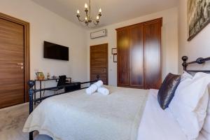 a bedroom with a bed with white pillows and a chandelier at Little Rhome Suites in Rome