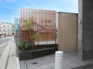 a fence on the side of a building at Hotel Trend JR Uji Ekimae in Uji