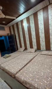 a group of three beds in a room at Shree ram lodge in Maihar