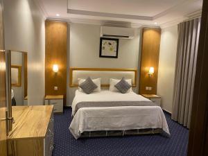 a hotel room with a bed and two pillows at شقق هذا منزلي المخدومة in Riyadh