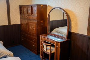 a bedroom with a dresser and a mirror on a desk at Taisho Roman-style Private Villa with Original Japanese Art 日本画原画の一棟貸し M's Lumos in Marugame +32 photos