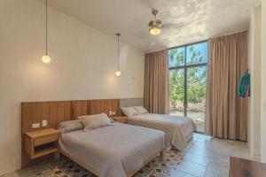 ein Schlafzimmer mit zwei Betten und einem Fenster in der Unterkunft Villas Marlé in Mococha