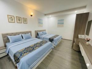 a hotel room with two beds and a television at Mermaid-Oasky-50m to ThápTamThắng&Biển in Vung Tau +36 photos