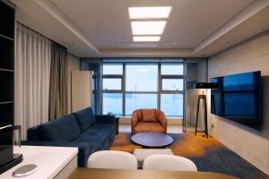 a living room with a couch and a tv at Matie Busan Harbor City in Busan