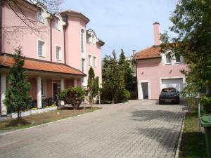 un'auto parcheggiata di fronte a due case rosa di Guest House Zamak a Banja Luka