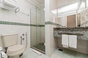 a bathroom with a toilet and a glass shower at Flat Serrano com Total Acesso ao Wish Resort in Gramado