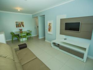 a living room with a couch and a tv at Residencial Villa Lobos in Torres