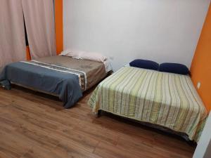two beds sitting next to each other in a room at Las Armonías Hostal in Panajachel +23 photos