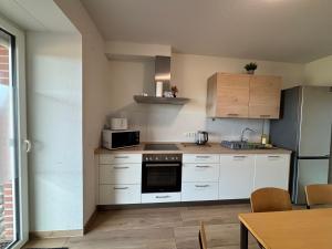 a kitchen with white cabinets and a stove top oven at Ferienhof von Hammel in Sevelten