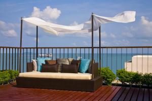
a bed sitting on top of a wooden bench at AYA Boutique Hotel Pattaya - SHA Plus in Pattaya
