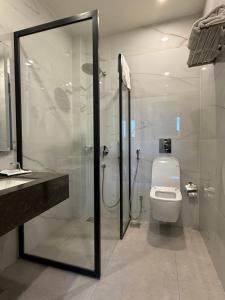 a bathroom with a toilet and a glass shower at S Chalet Islamabad in Islamabad +120 photos