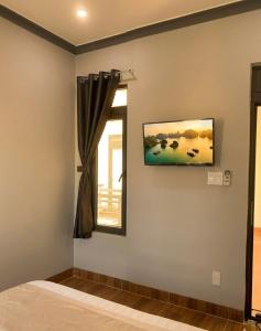 a bedroom with a window and a painting on the wall at Du Mục in Thôn Mỹ Phước