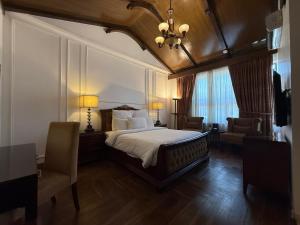 a bedroom with a bed and two chairs and a chandelier at S Chalet Islamabad in Islamabad