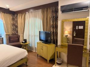 a hotel room with a bed and a television at S Chalet Islamabad in Islamabad