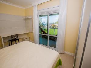 a bedroom with a bed and a large window at Residencial Villa Lobos in Torres