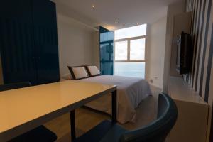 a bedroom with a bed and a desk and a window at Virginia's Dream Panoramic Sea View Loft in Las Palmas de Gran Canaria