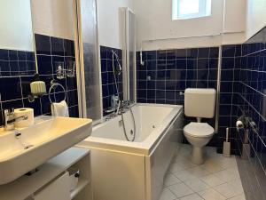 a bathroom with a tub and a toilet and a sink at Le Style Haussmannien in Tramelan +31 photos