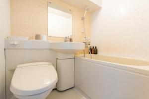 a white bathroom with a toilet and a sink at Koraku Garden Hotel Tokyo in Tokyo +114 photos