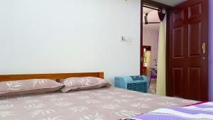 a bedroom with a bed with two pillows on it at Leland Homestay in Mararikulam