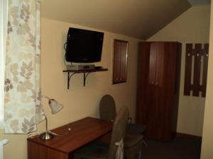 a room with a desk and a tv on the wall at Hotel Primagor in Szydłowiec