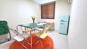 a room with a table and chairs and a refrigerator at 호텔 도토리 in Gunsan-si