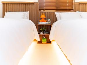 a bedroom with two beds with white comforters at 호텔 도토리 in Gunsan-si