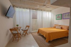a bedroom with a bed and a tv and a table at Las Guayas, depto Ceh in Progreso