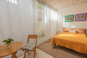 a bedroom with a bed and a table and a window at Las Guayas, depto Ceh in Progreso