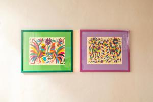 three paintings of flowers are hanging on a wall at Las Guayas, depto Ceh in Progreso